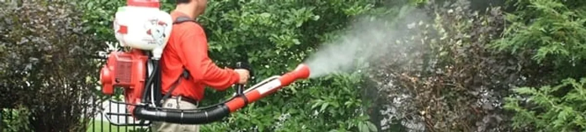 Mosquito control technician fogging shrubs and landscaping for mosquito treatment in Pembroke PInes, FL