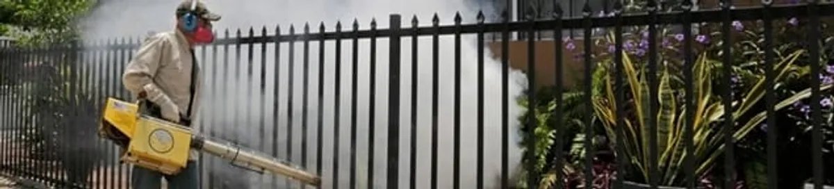 Mosquito control technician fogging a yard perimeter for mosquito reduction in Pembroke PInes, FL